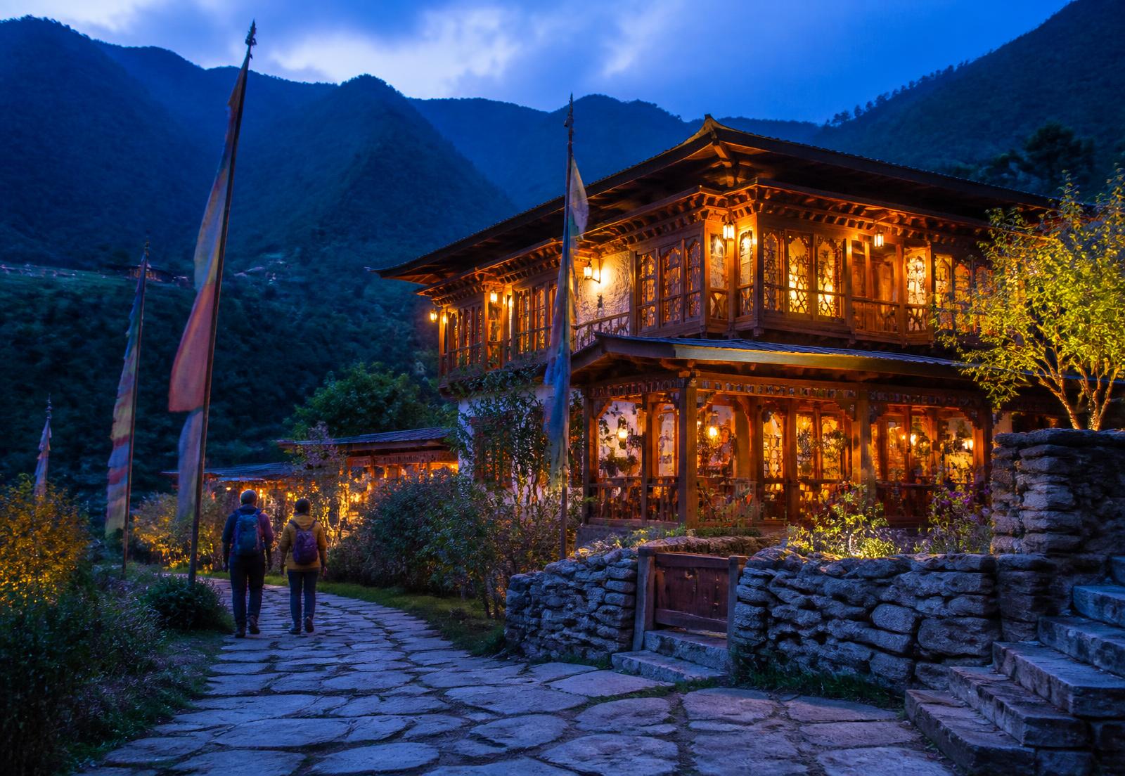 Travelers arriving at a traditional Bhutanese lodge